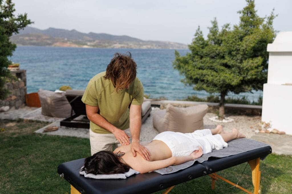 woman receiving massage outdoors with sea view in Milos Greece