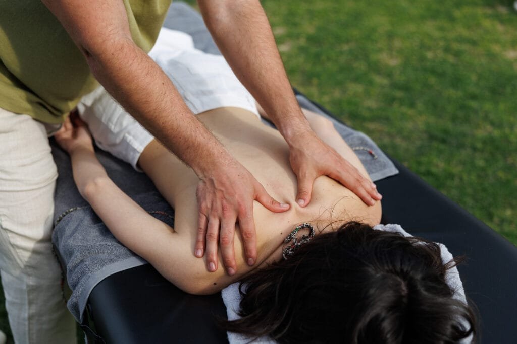 hands pressing shoulder muscles during therapeutic massage