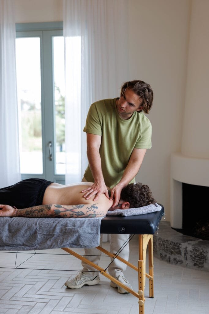 therapist working on back muscles during indoor bodywork therapy
