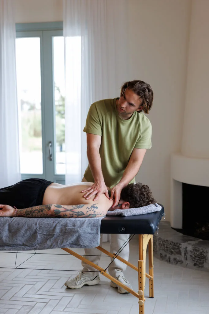 therapist working on back muscles during indoor bodywork therapy